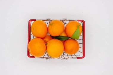 Beyaz arka planda metal sepette Sicilya portakalları ve mandalinalar