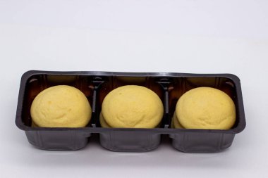 Kahverengi tabakta kremalı birkaç parça limonlu bisküvi.