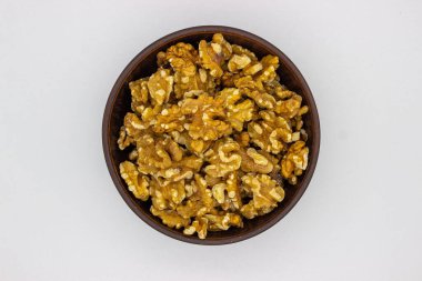 Beyaz arka planda kahverengi tabakta soyulmuş ceviz izole bir görüntüdür..