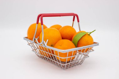 Beyaz arka planda metal sepette Sicilya portakalları ve mandalinalar