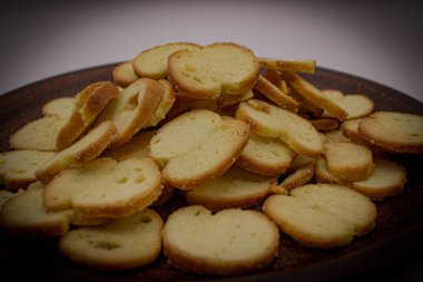 Kızarmış ekmek cipsleri tabakta baharatlı.