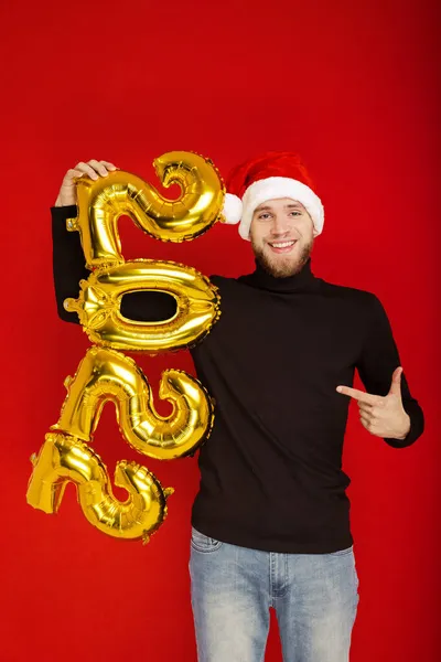 サンタクロースの帽子の男の肖像画と赤の背景に2022の数 — ストック写真
