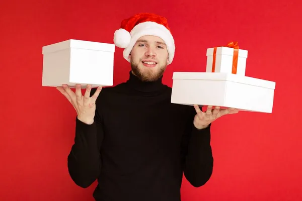 산타클로스 모자를 남자가 선물중 하나를 — 스톡 사진