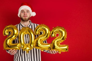 2022 numaralı Noel şapkalı bir adam. Yeni yıl yaklaşıyor.