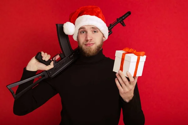 像圣诞老人这样拿着机关枪和新年礼物的男人 — 图库照片