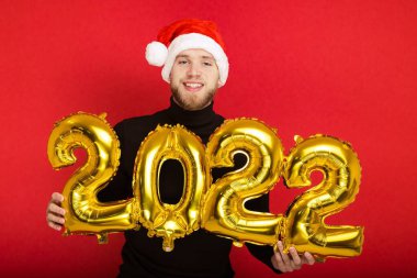 Noel Baba şapkalı bir adamın portresi ve kırmızı arka planda 2022 rakamları var.