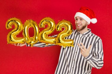 2022 numaralı Noel şapkalı bir adam. Yeni yıl yaklaşıyor.