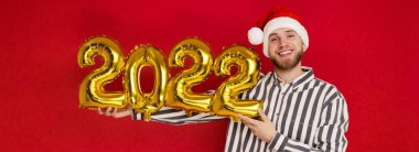2022 numaralı Noel şapkalı bir adam. Yeni yıl yaklaşıyor.