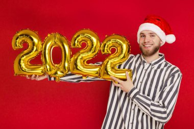 2022 numaralı Noel şapkalı bir adam. Yeni yıl yaklaşıyor.