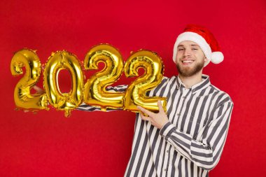 2022 numaralı Noel şapkalı bir adam. Yeni yıl yaklaşıyor.