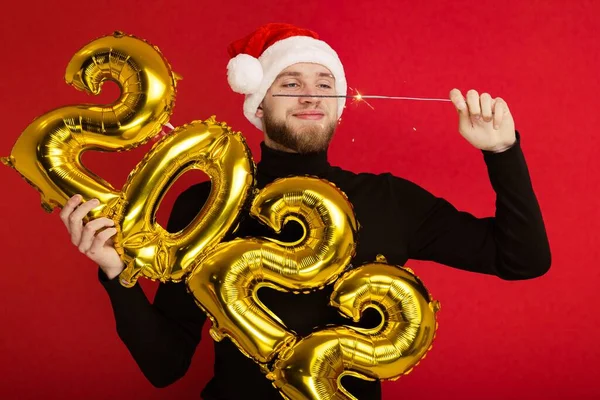 산타클로스 모자를 남자가 2022 번호와 스파클러를들고 — 스톡 사진