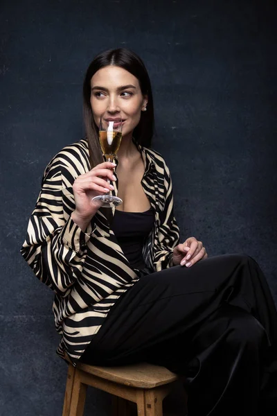 Праздники Молодая Женщина Умной Рубашке Брюках Сидящих Стуле Пьющих Шампанское — стоковое фото