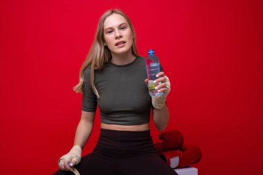 Atletik genç bayan boks eğitiminden sonra su içiyor.