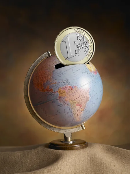 Globe, map of the earth, made ??as a money box, with euro coins — Stock Photo, Image