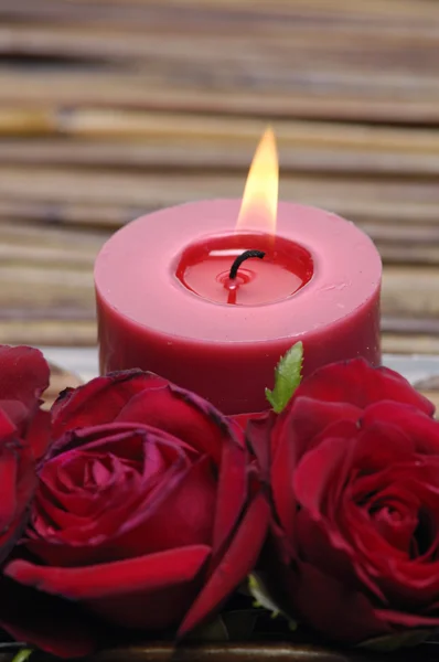 Свечи с красными лепестками роз — стоковое фото