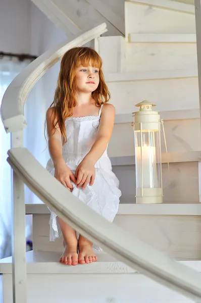Little red-haired girl on the stairs — Stock Photo, Image