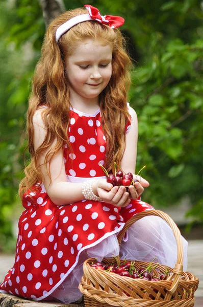 Girl in with a basket of cherries — Stock Photo, Image