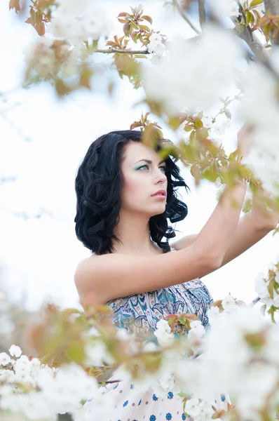 Chica joven en un jardín floreciente — Foto de Stock