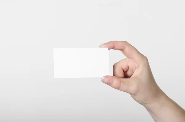 Mão com cartão branco sobre um fundo branco — Fotografia de Stock