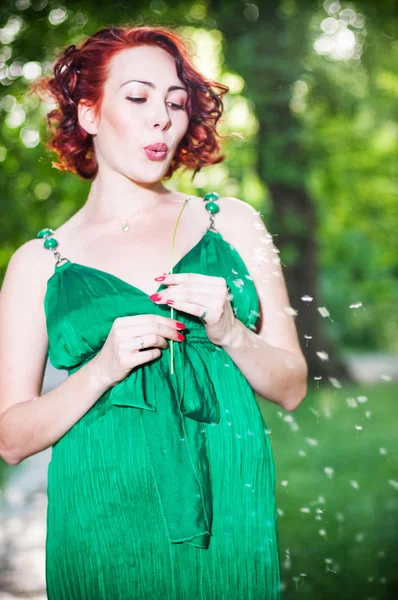 年轻孕妇在一条绿色连衣裙 — 图库照片