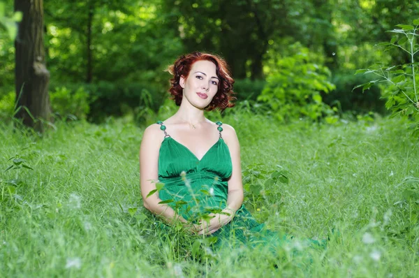 Yeşil giysili genç hamile kadın — Stok fotoğraf