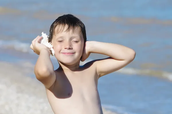 男孩与壳牌在海滩上的手 — 图库照片