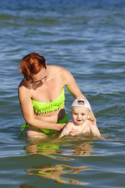Madre e bambino sulla spiaggia in mare — Foto Stock