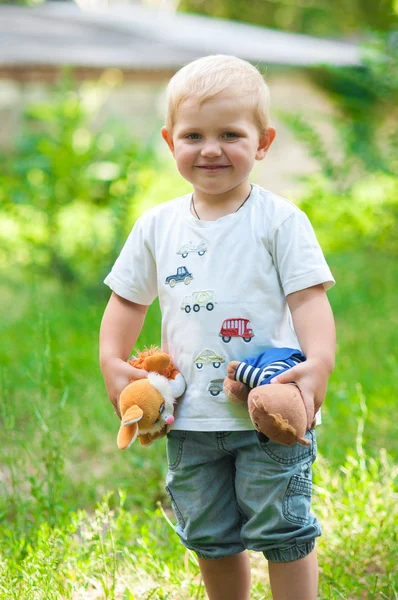 Criança andando no parque com um brinquedo — Fotografia de Stock