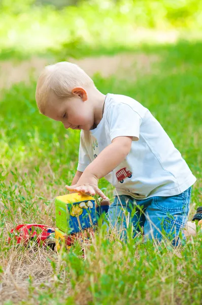 Criança andando no parque com um brinquedo — Fotografia de Stock