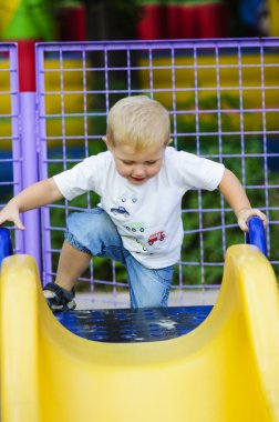 Parkta bir çocuk slayt üzerinde küçük çocuk