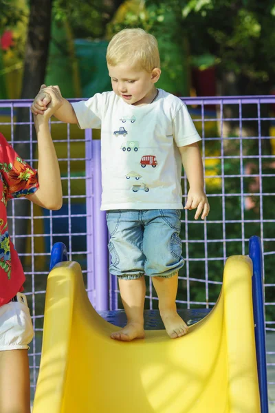 Little boy on a children's slide in the park — Stock Photo, Image