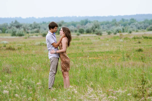 Young girl and a young man in the field of sunflowers — Stock Photo, Image