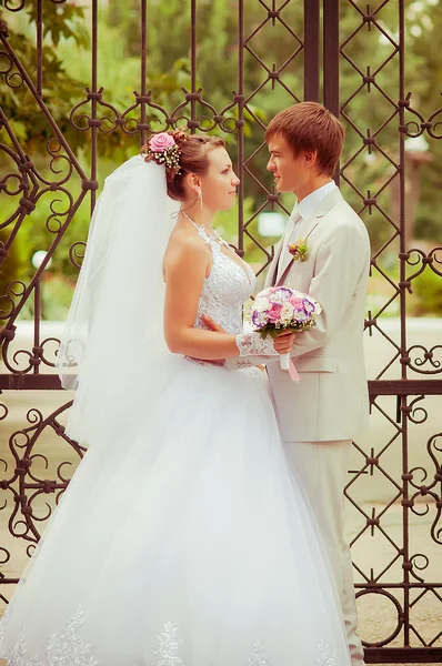 Красивая невеста и жених улыбаются друг другу — стоковое фото