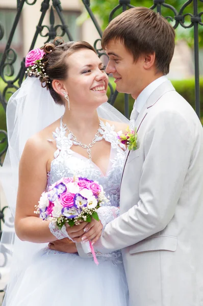 Schöne Braut und Bräutigam lächeln einander an — Stockfoto