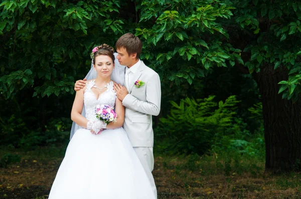 Beautiful bride and groom smiling at each other — Stock Photo, Image