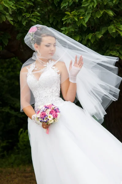 Cantik pengantin dalam gaun putih dengan buket di tangan — Stok Foto