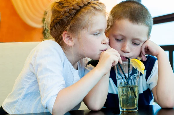 Garçon et fille boire un verre avec de la glace à travers une paille — Photo