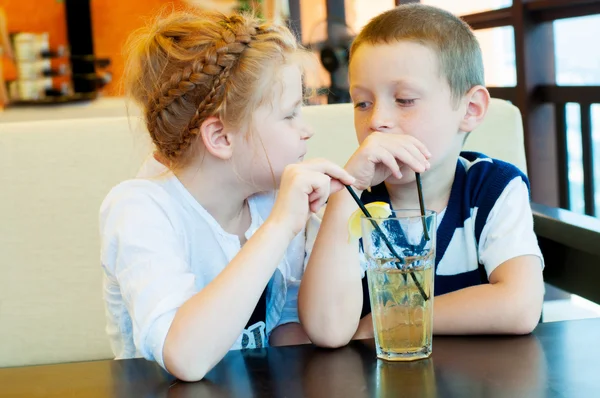 Boy and girl drinking a drink with ice through a straw — Stock Photo, Image