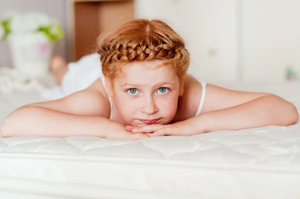 Маленькая девочка с рыжими волосами в белом платье — стоковое фото