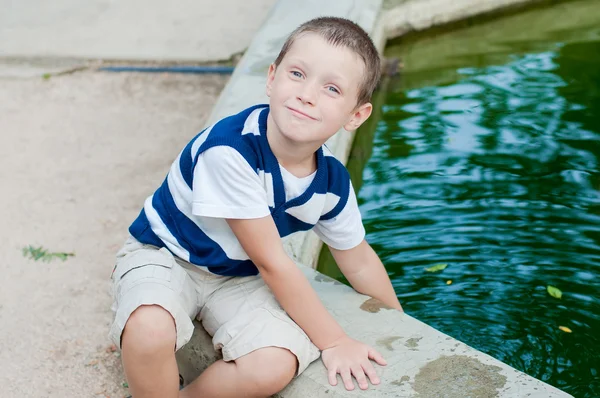 Junge spielt am Brunnen — Stockfoto