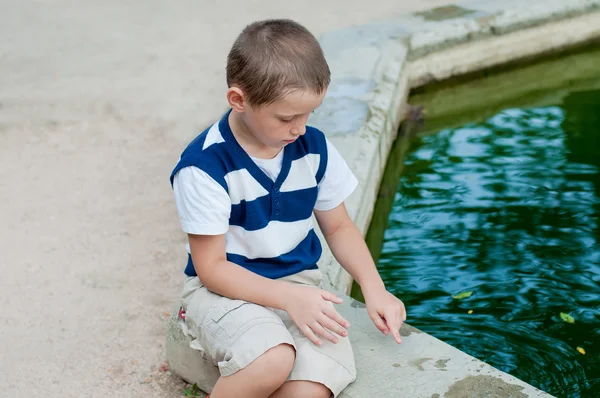 Jongen spelen bij de fontein — Stockfoto