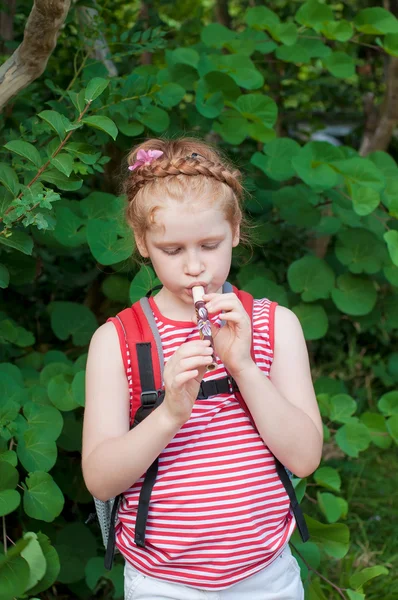 Flicka som leker en pipa i naturen — Stockfoto