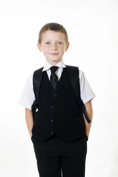 Ragazzino con uno zaino scolastico e libri su sfondo bianco — Foto Stock