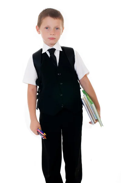 Niño pequeño con una mochila escolar y libros sobre fondo blanco — Foto de Stock