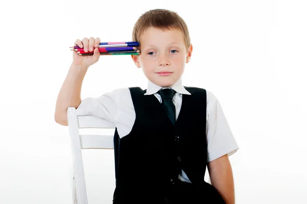 Little boy in the chair with pencils and books — Stock Photo, Image