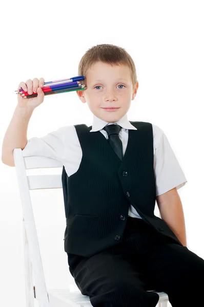 Kleiner Junge im Stuhl mit Bleistiften und Büchern — Stockfoto