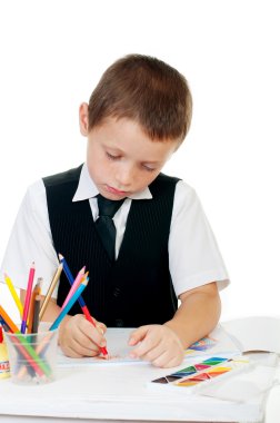 çocuk beyaz bir arka plan üzerinde bir albümde kalem çizer