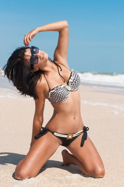 Ung vacker flicka i en bikini på en strand — Stockfoto