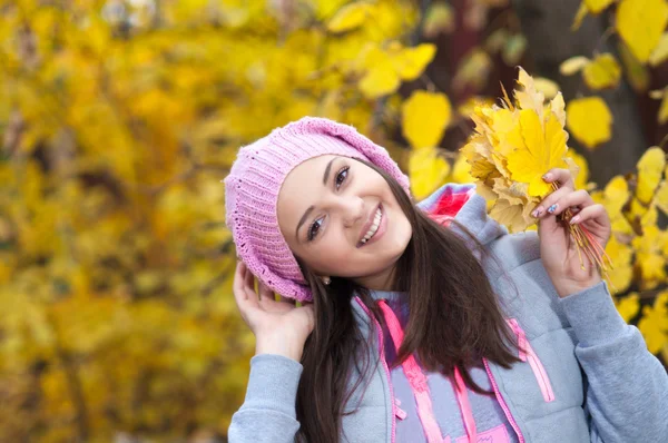 Young girl in a park in autumn with yellow leaves — Stock Photo, Image