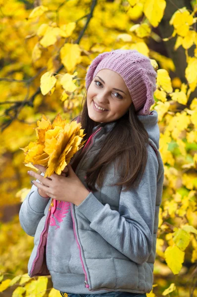 Young girl in a park in autumn with yellow leaves — Stock Photo, Image